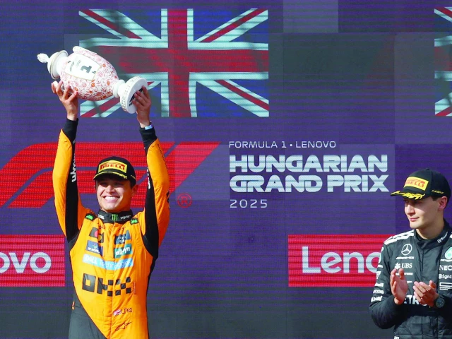 mclaren s lando norris celebrates on the podium with the trophy after winning the hungarian grand prix photo reuters