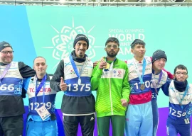 special olympics pakistan athlete poses at the podium with others at the special olympics world winter games in turin with his gold medal photo courtesy sop