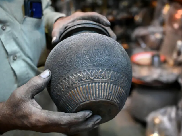 Antique dealer Ahsan Shakeel shows an artefact at his shop selling vintage items in Rawalpindi. PHOTO: AFP