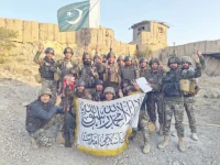 pakistani soldiers pose with the national flag at a captured check post inside afghanistan while showing respect for the enemy flag