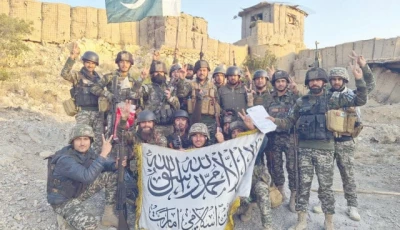 pakistani soldiers pose with the national flag at a captured check post inside afghanistan while showing respect for the enemy flag