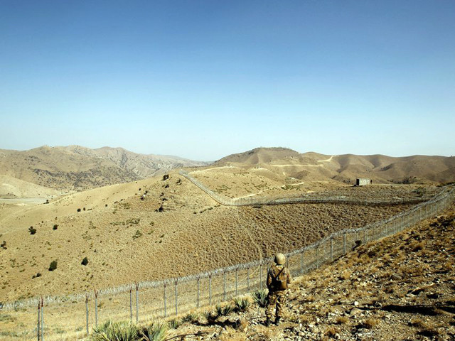 a soldier stands guard along the border fence outside the kitton outpost on the border with afghanistan in north waziristan photo reuters file