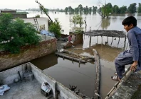 a flood affected villager looks at the overflowing river sutlej as he sits over the rooftop of his house in kasur district punjab province on september 3 2025 photo afp