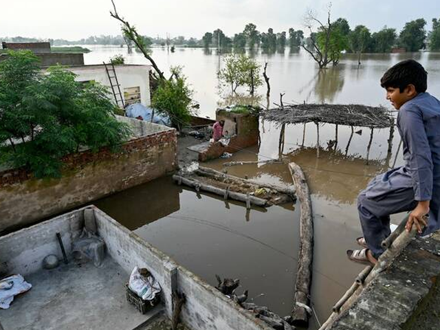 A flood-affected villager looks at the overflowing river Sutlej, as he sits over the rooftop of his house in Kasur district, Punjab province on September 3, 2025. Photo: AFP