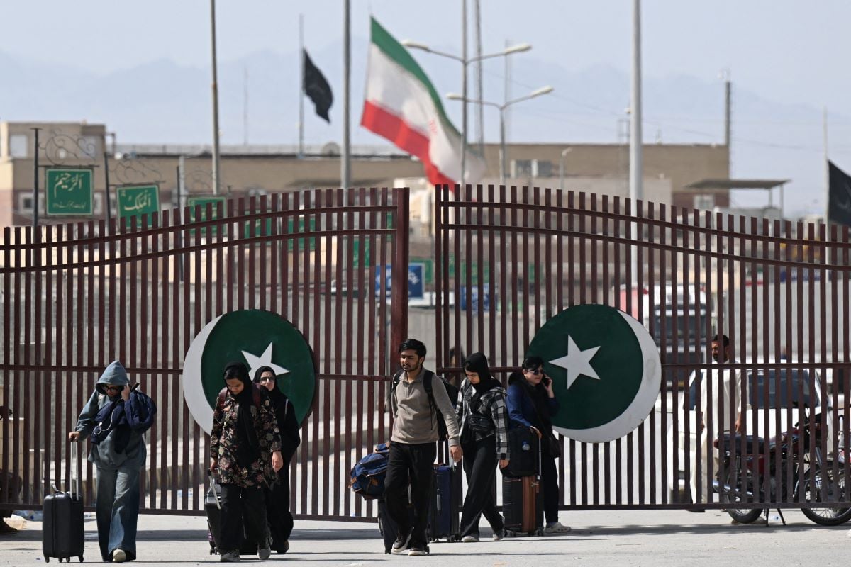 Pakistanis walk across the Taftan border as they return from Iran, in Balochistan province on March 3, 2026 amid ongoing US-Israel strikes on Iran. PHOTO: AFP