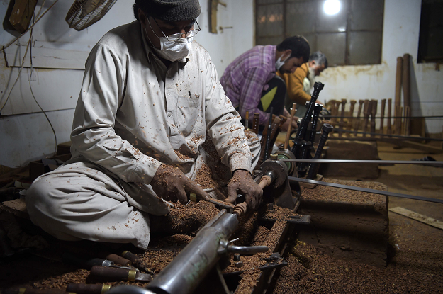 In this picture taken on January 25, 2019, Pakistani artisans work on machines to make components to be used in bagpipes at the Mid East bagpipe factory in the eastern city of Sialkot. PHOTO: AFP