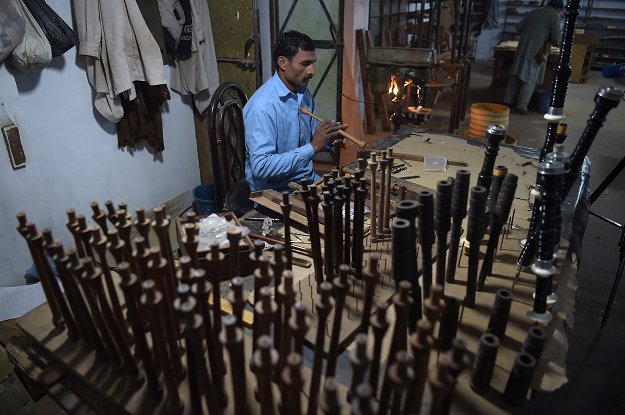 In this picture taken on January 25, 2019, a Pakistani worker makes components used in bagpipes at the Mid East bagpipe factory in the eastern city of Sialkot. PHOTO: AFP