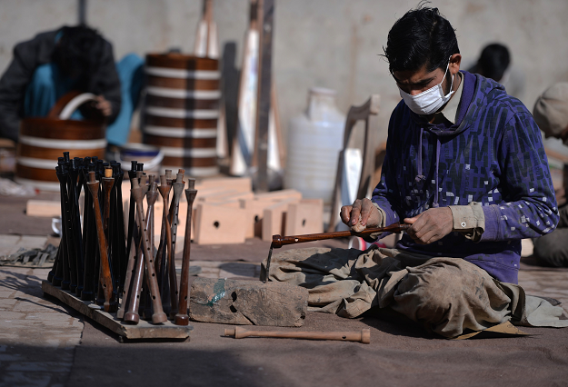 In this picture taken on January 25, 2019, a Pakistani worker polishes a component to be used to make a set of bagpipes at the Mid East bagpipe factory in the eastern city of Sialkot. PHOTO: AFP