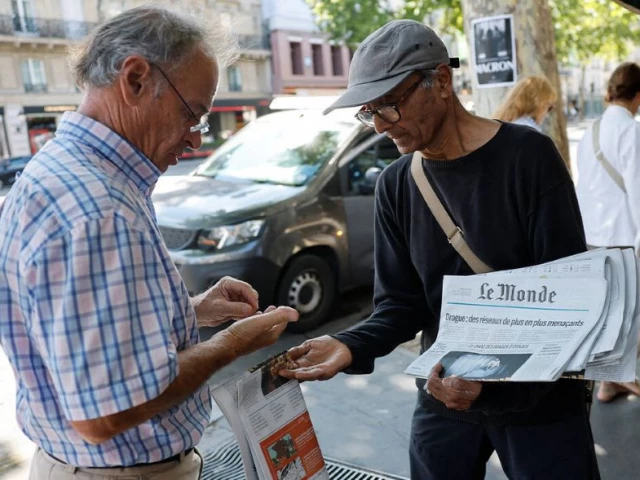 ali akbar 73 known as the last newspaper hawker in the french capital sells le monde newspaper to a man on the street in the latin quarter in paris france august 4 2025 photo reuters ali akbar 73 known as the last newspaper hawker in the french capital sells le monde newspaper to a man on the street in the latin quarter in paris france august 4 2025 photo reuters