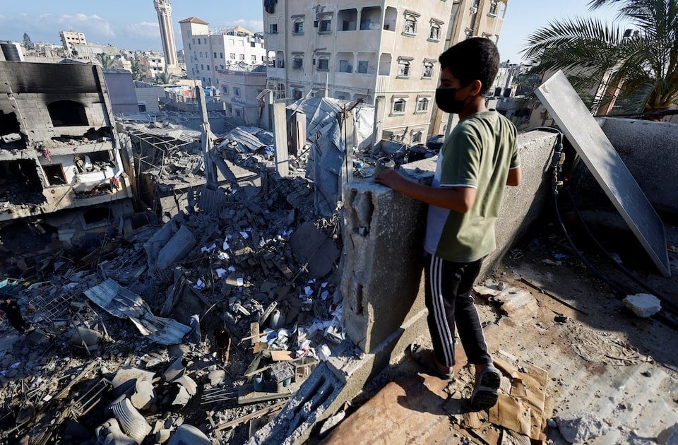 A Palestinian boy looks at the site of an Israeli strike on a house that was pre-warned by the Israeli military to evacuate before the strike was carried out late on Saturday, in Deir al-Balah, in the central Gaza Strip, May 24, 2026. REUTERS