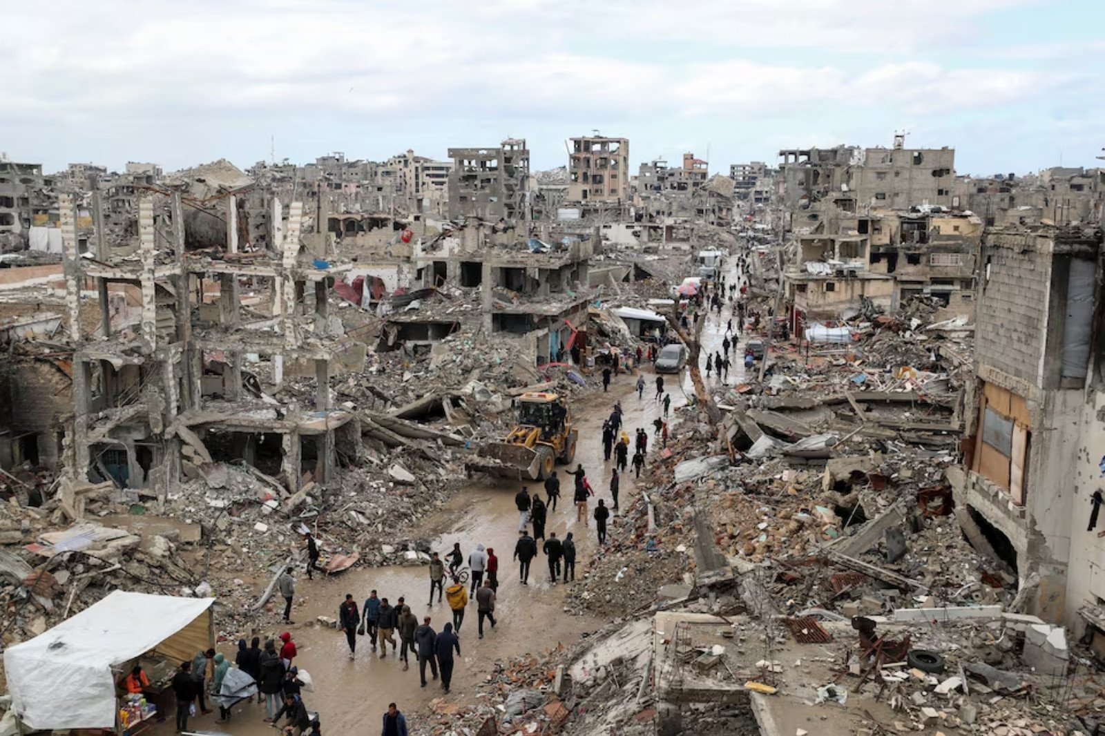 palestinians walk past the rubble of buildings destroyed during the israeli offensive on a rainy day amid a ceasefire between israel and hamas in gaza on february 6 2025 photo reuters