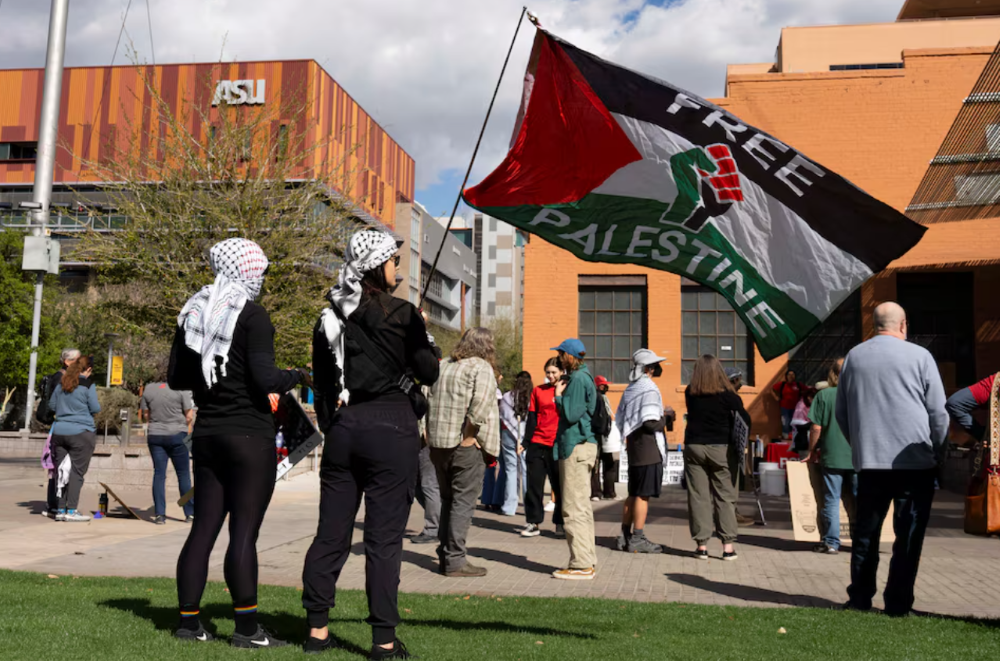 protesters wearing keffiyehs wave a pro palestinian flag during a protest against the ice detention of palestinian activist and columbia university graduate student mahmoud khalil near arizona state university asu in phoenix arizona u s march 15 2025 photo reuters