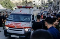an ambulance waiting in the middle of the road in palestine as onlookers gather around it photo aa file