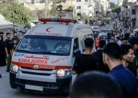 an ambulance waiting in the middle of the road in palestine as onlookers gather around it photo aa file
