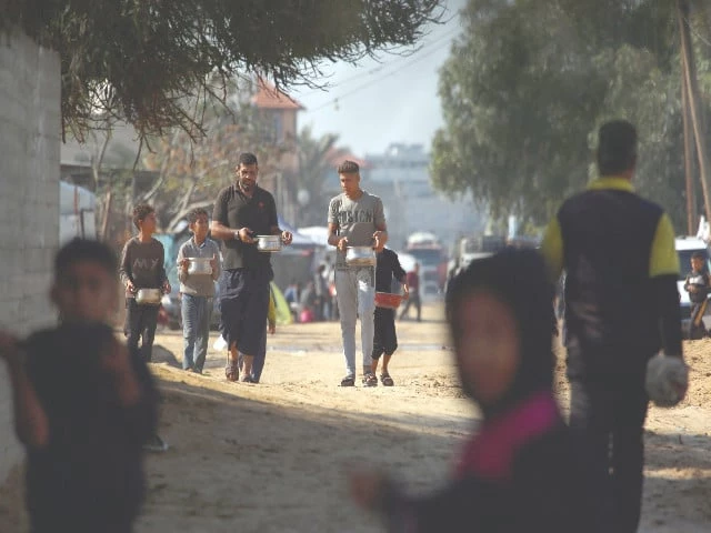 palestinians carry pots with food west of deir al balah city in the central gaza strip photo afp palestinians carry pots with food west of deir al balah city in the central gaza strip photo afp