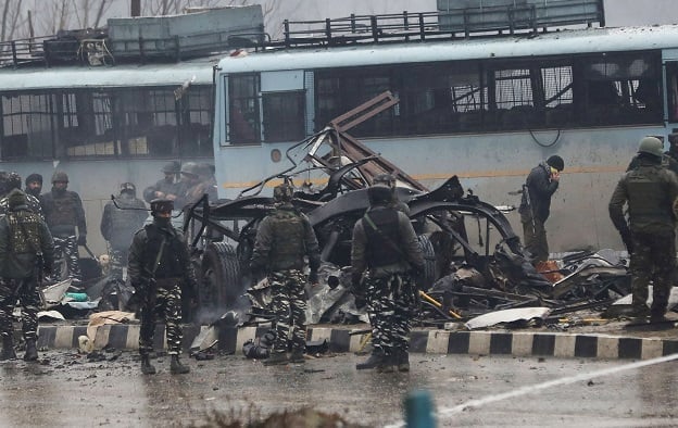 Indian security forces inspect the remains of a bus following an attack on a paramilitary Central Reserve Police Force (CRPF) convoy. -AFP