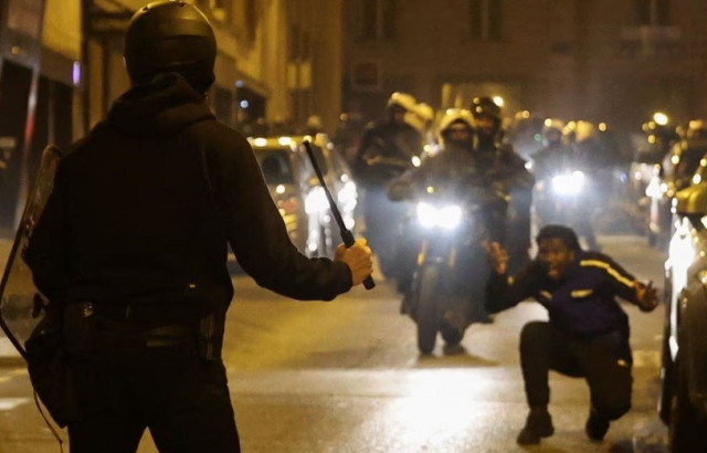 a person reacts while a police officer holds a baton during protests following the death of nahel a 17 year old teenager killed by a french police officer in nanterre during a traffic stop in paris france july 2 2023 reuters nacho doce a person reacts while a police officer holds a baton during protests following the death of nahel a 17 year old teenager killed by a french police officer in nanterre during a traffic stop in paris france july 2 2023 reuters nacho doce