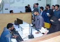 people crowding the facilitation desk to receive their passports photo app file