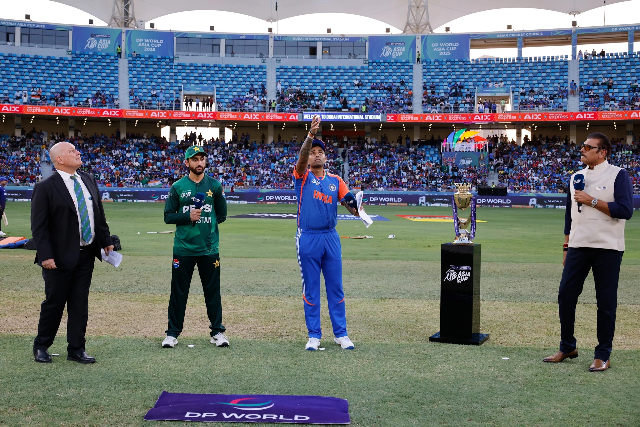 indian captain suryakumar yadav tosses the coin as pakistan skipper agha salman looks on ahead of the highly anticipated asia cup 2025 clash between india and pakistan at the dubai international stadium photo pcb
