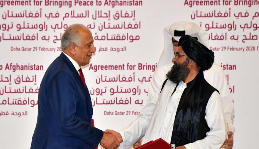 zalmay khalilzad and mullah abdul ghani baradar shake hands photo afp