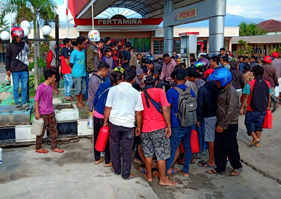 People collect fuel at a petrol station. PHOTO:  REUTERS