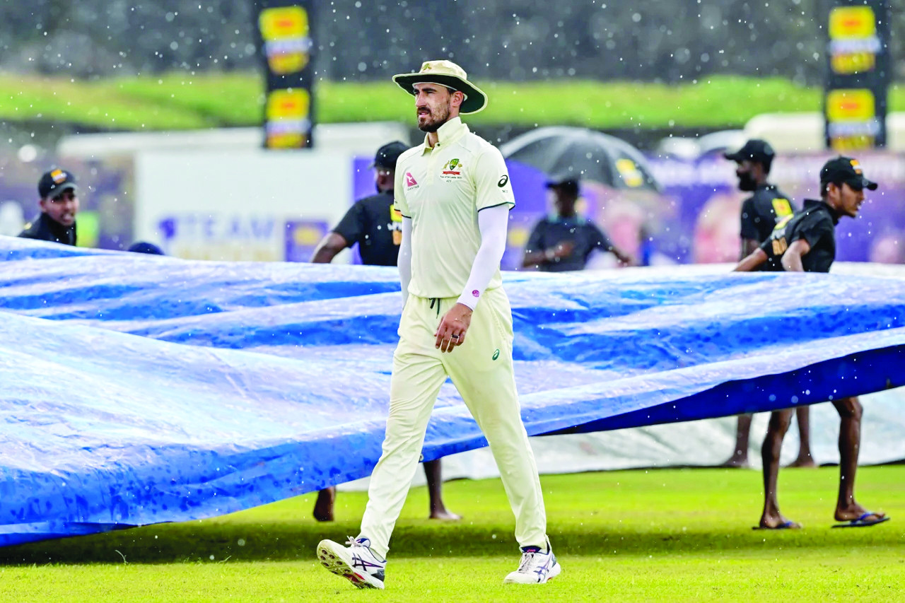 mitchell starc walks off in the rain as the covers come on photo afp