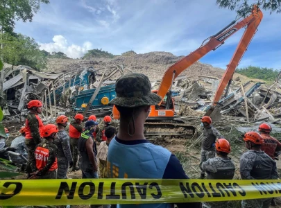at least two dead as garbage landslide buries dozens in central philippines
