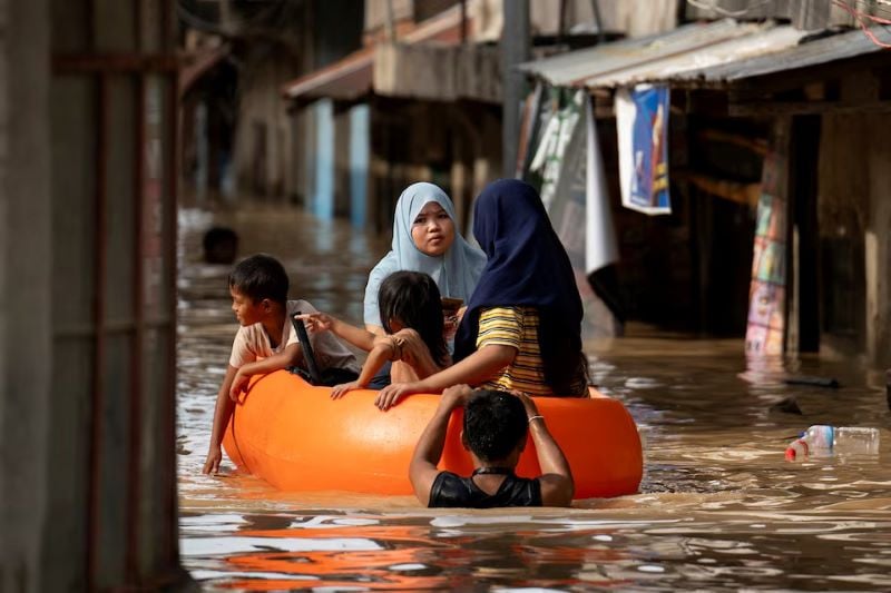 people ride on a rescue boat along a flooded street following super typhoon man yi in cabanatuan nueva ecija philippines november 18 2024 photo reuters