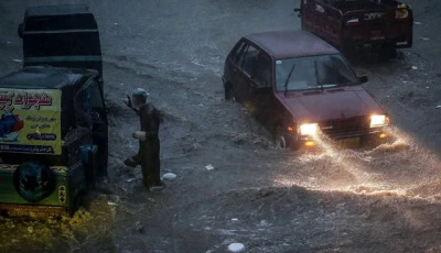 commuters make their way through a flooded street during heavy monsoon rains in hyderabad on july 14 2025 photo afp