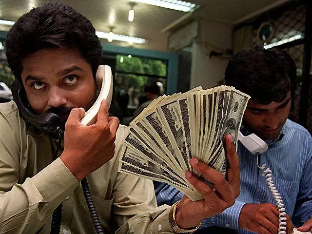 pakistani money dealers busy on their telephones photo afp pakistani money dealers busy on their telephones photo afp