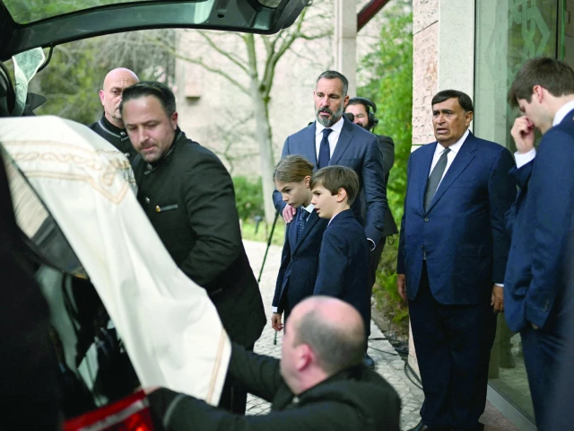 prince rahim al hussaini aga khan v c accompanied by his sons prince irfan and prince sinan looks at the coffin with the remains of his father aga khan iv during his funeral at the ismaili community centre in lisbon photo afp