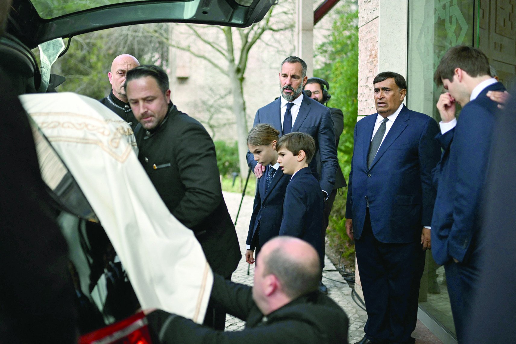 prince rahim al hussaini aga khan v c accompanied by his sons prince irfan and prince sinan looks at the coffin with the remains of his father aga khan iv during his funeral at the ismaili community centre in lisbon photo afp