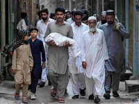a man carries the body of a newborn who died in the pims hospital fire during the funeral in rawalpindi photo afp