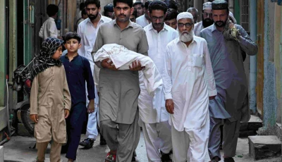 a man carries the body of a newborn who died in the pims hospital fire during the funeral in rawalpindi photo afp