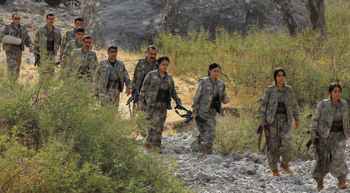 Fighters with the Kurdistan Workers' Party (PKK) walk to a disarmament ceremony marking a significant step toward ending the decades-long conflict between Turkey and the outlawed group, in the Qandil mountains, Iraq October 26, 2025.PHOTO:  REUTERS