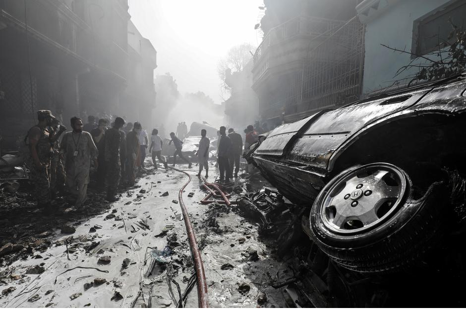 Rescue workers gather at the site of a passenger plane crash in a residential area near an airport in Karachi. PHOTO: REUTERS