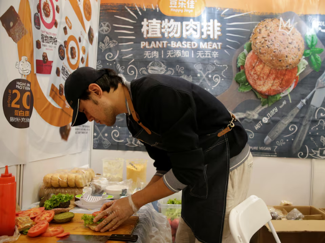 A cook makes a burger with a plant-based patty at VeggieWorld fair in Beijing, China November 8, 2019. Picture taken November 8, 2019. PHOTO: Reuters