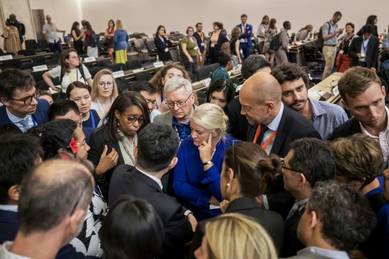 Delegates speak after talks on a global treaty on combating plastic pollution were extended an extra day in Geneva Photo: Fabrice COFFRINI/AFP