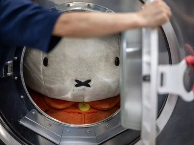 Dry-cleaning professional Masakazu Shimura puts a a soft toy into a washing machine at the facility of Cleaning Yonmarusan in Fuefuki city of Yamanashi Prefecture © Philip FONG / AFP