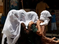 men ride on a motorbike as they cover their heads with a wet cloth to cool off and to avoid sunlight during a hot summer day as the heatwave continues in jacobabad pakistan may 26 photo reuters