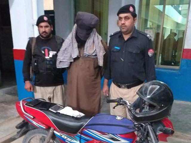 police pose with the man arrested for the murder of ahmaddiya community professor in peshawar photo express
