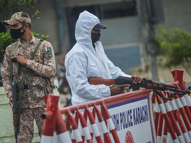 a policeman r stands along a paramilitary soldier at a security check point on a street as a lockdown was imposed to curb the spread of the covid 19 in karachi photo afp file