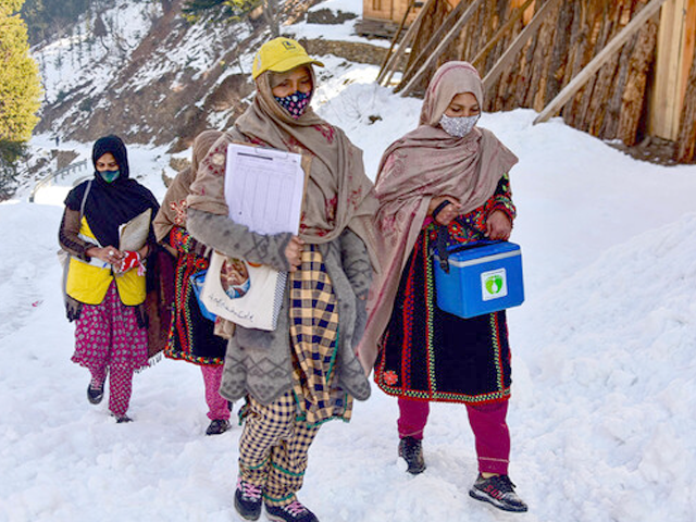 health workers walk on snow during a polio vaccination drive in azad jammu kashmir s neelum valley on february 4 2025 photo afp