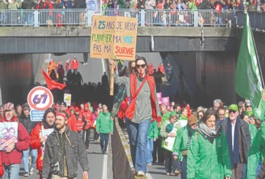 a protester holds a sign reading at 25 years i want to plan my life not my survival during a demonstration in brussels on a national day of action against the federal arizona government s austerity plan photo afp