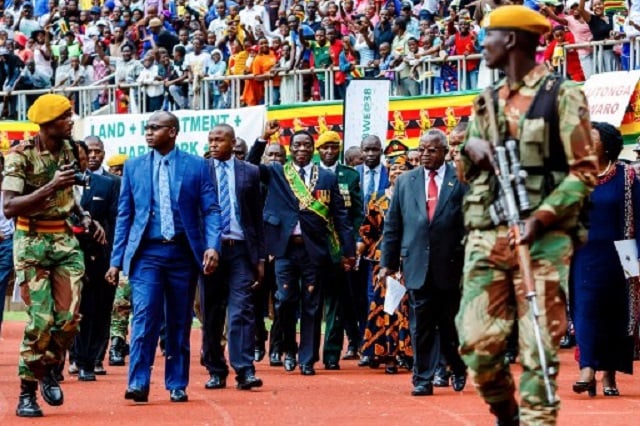 President Emmerson Mnangagwa (C-R) inspects a military guard of honour during Independence Day celebrations. PHOTO: AFP