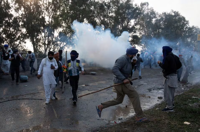 farmers who are marching towards new delhi to press for the better crop prices promised to them in 2021 run for cover amidst tear gas smoke fired by police to disperse them at shambhu a border crossing between punjab and haryana states india february 13 2024 reuters rohit lohia file photo