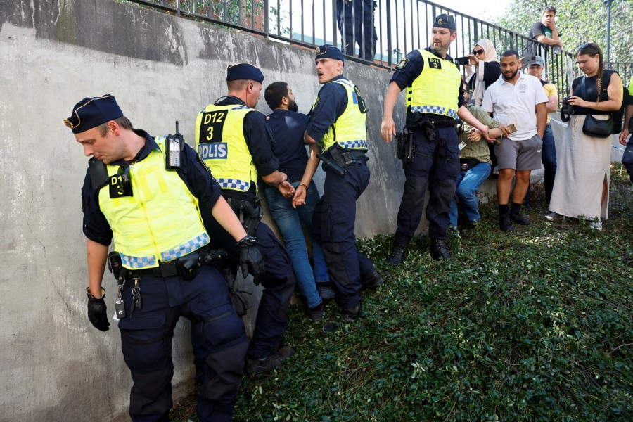 police officers intervene after people s reaction as demonstrators desecrate the holy quran not pictured outside stockholm s central mosque in stockholm sweden june 28 2023 photo reuters