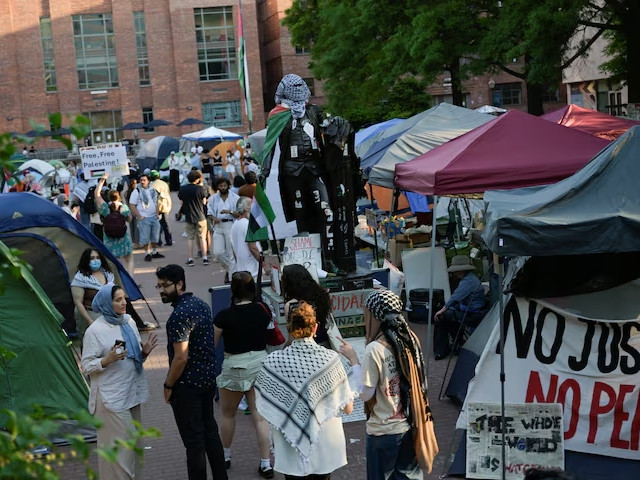 people stand around a statue of george washington tied with a palestinian flag and a keffiyeh inside a pro palestinian encampment at george washington university in washington dc u s may 2 2024 photo reuters