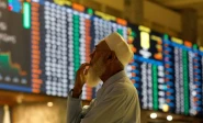 a stock broker reacts while monitoring the market on the electronic board displaying share prices during trading session at the pakistan stock exchange in karachi on july 3 2023 photo reuters file