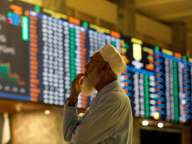 a stock broker reacts while monitoring the market on the electronic board displaying share prices during trading session at the pakistan stock exchange in karachi on july 3 2023 photo reuters
